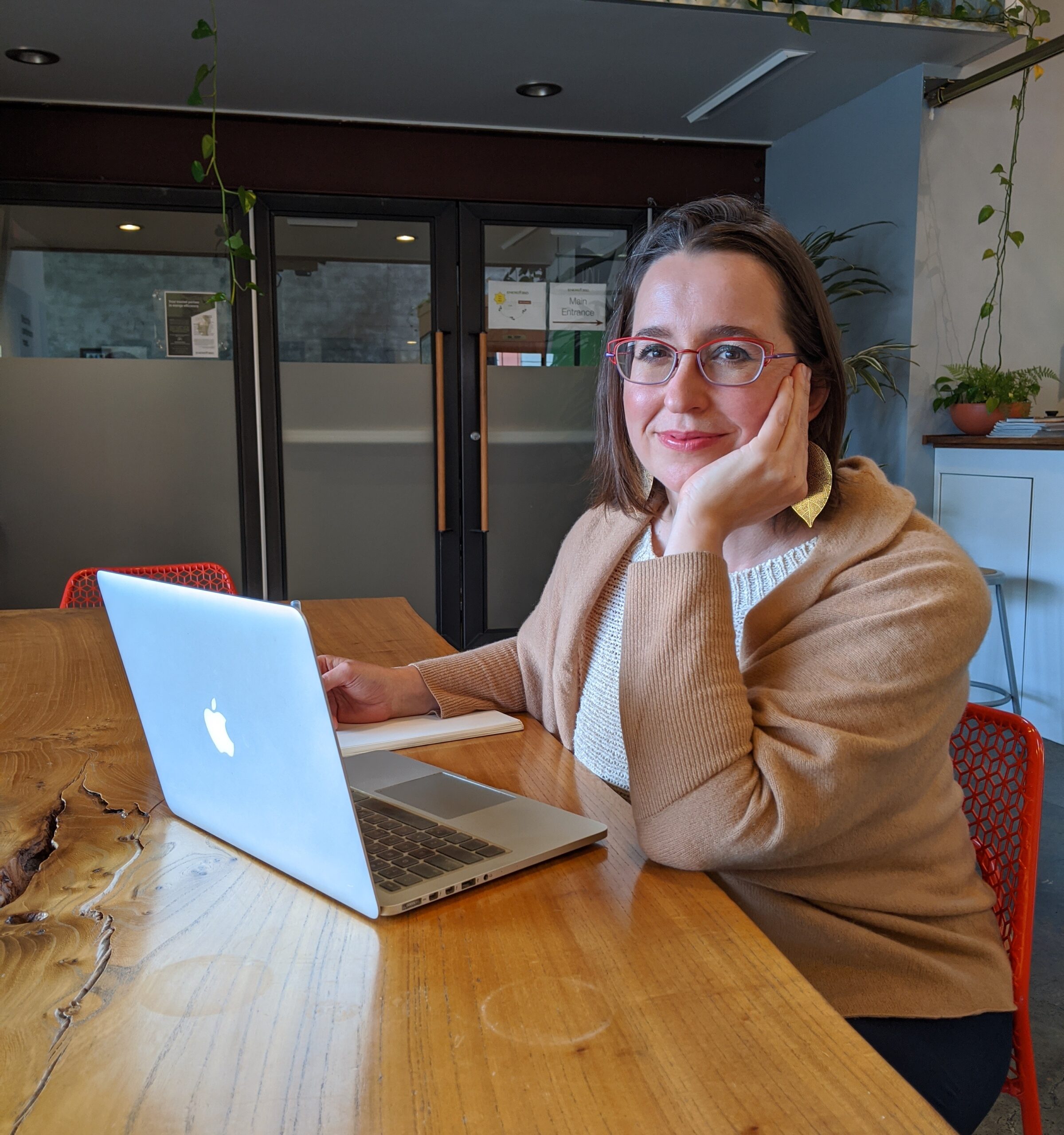 a picture of a pale person with glasses at a computer looking at the camera